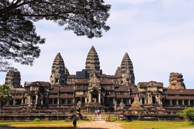 Chrámový komplex Angkor Wat se stromy a návštěvníky.