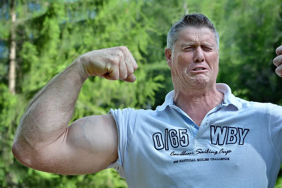 Muž při póze s napnutým bicepsem, ilustrační fotografie ke sportovní výživě