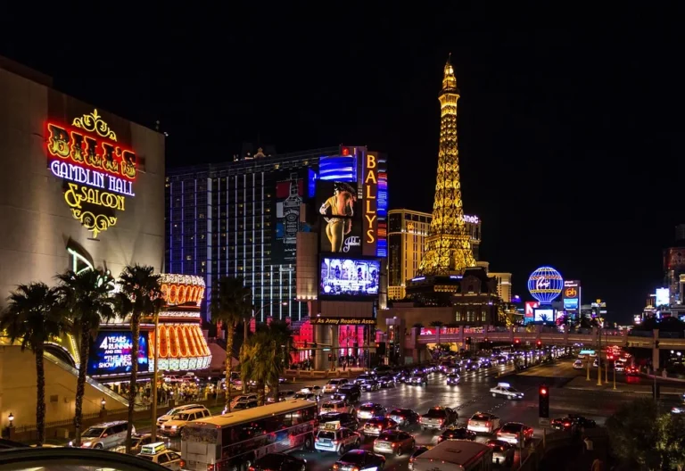 Osvětlené hotelové budovy a ulice v Las Vegas večer.