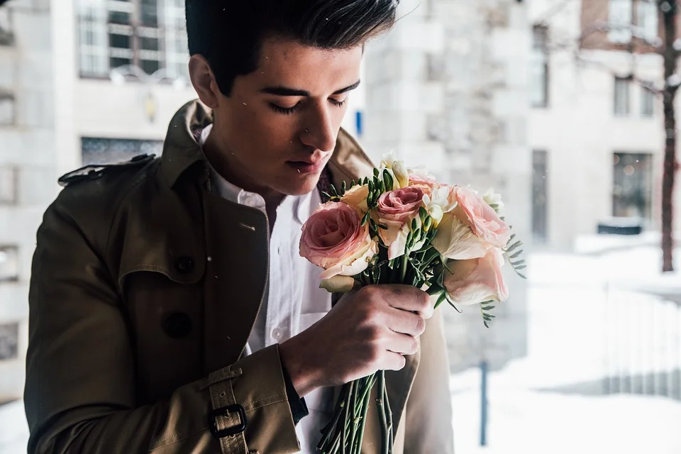 Muž drží malou kytici květin jako osobní dárek.