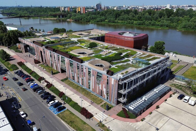 Budova Centrum Nauki Kopernik se zelenou střechou u Visly ve Varšavě
