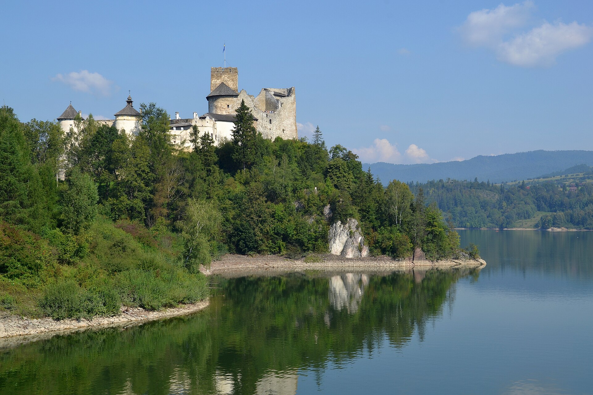Hrad Niedzica na zeleném výběžku nad vodou Czorsztynského jezera