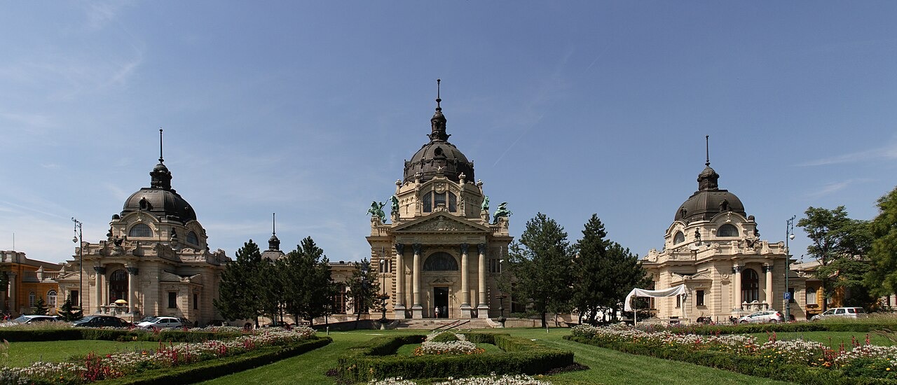 Žlutá historická fasáda a zahradní průčelí lázní Széchenyi