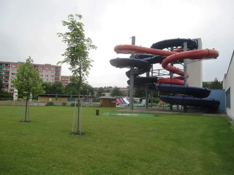 Venkovní část Aquaparku Uherské Hradiště s věží tobogánů a trávníkem letního areálu