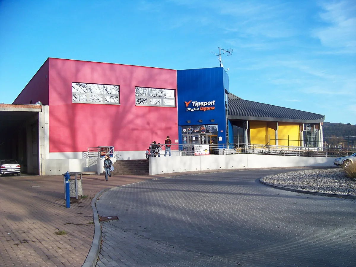 Vstup do plaveckého areálu Tipsport Laguna v Berouně s červenou, modrou a žlutou fasádou