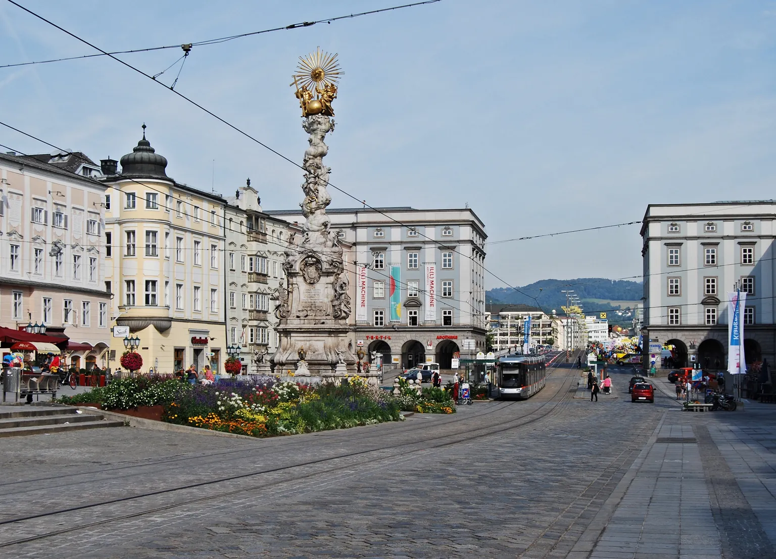 Archivní fotografie Hauptplatzu v Linci s tramvají a sloupem Nejsvětější Trojice.