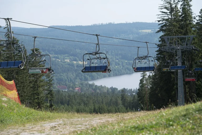 Sedačková lanovka nad sjezdovkou v areálu Lipno s výhledem na lipenské jezero, letní snímek