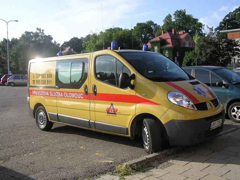 Žlutý sanitní vůz převozové služby zaparkovaný na parkovišti v Olomouci, nejde o vůz záchranné služby