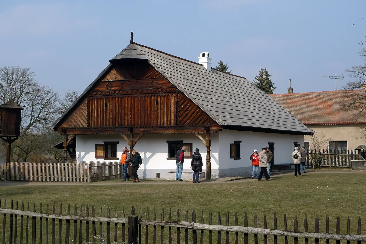 Staročeská chalupa s vyřezávanou lomenicí a šindelovou střechou ve skanzenu v Přerově nad Labem