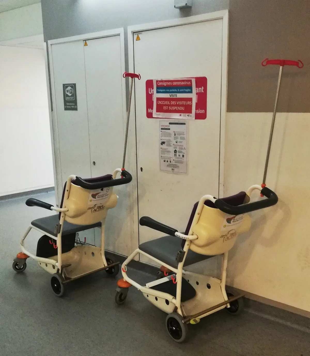 Mechanické invalidní vozíky odstavené na nemocniční chodbě