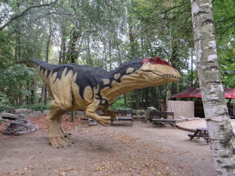Model dravého dinosaura mezi stromy v DinoParku Vyškov
