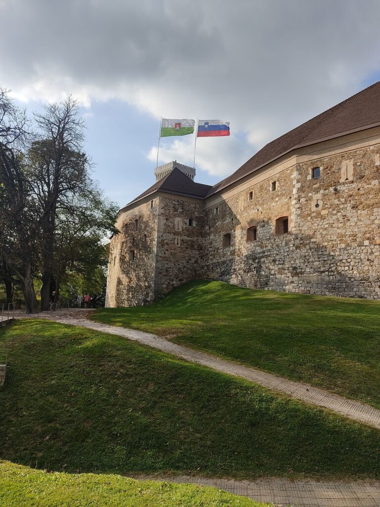Kamenné hradby Lublaňského hradu se slovinskými vlajkami