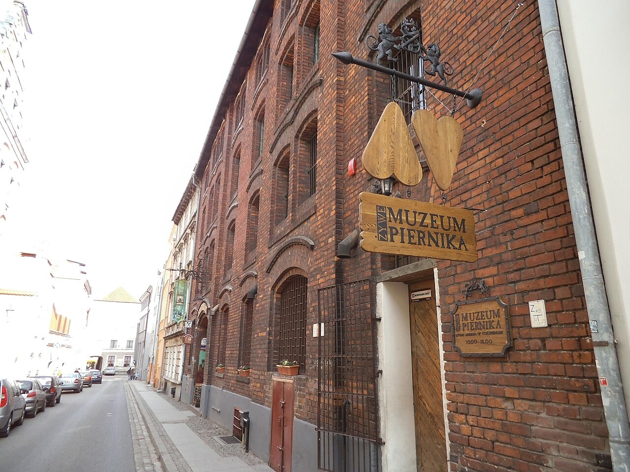 Cihlová budova Żywe Muzeum Piernika s vývěsním štítem v Toruni