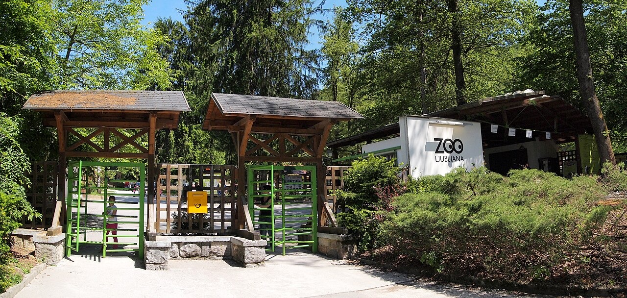 Zelená výstupní brána Zoo Lublaň s dřevěnými přístřešky